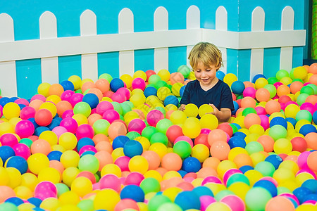 快乐的小男孩在多彩的塑料球游乐场玩耍 高风景 有趣的孩子在室内玩得开心蓝色头发运动游戏创造力气泡校园幼儿园乐趣微笑图片