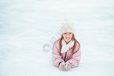 秋天后还穿着溜冰鞋坐在冰上的小可爱女孩活动女儿闲暇爱好数字滑冰场速度溜冰者溜冰童年图片