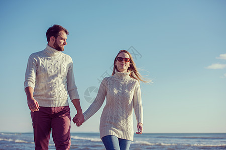 秋天阳光明媚的一天 在海滩上爱一对年轻夫妇自拍拥抱女士晴天乐趣记忆夫妻男人冒充男性图片