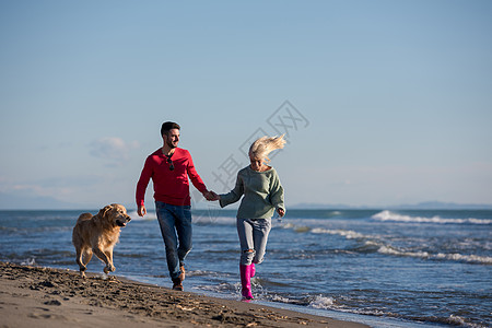 宝宝和狗在自闭症日海滩上玩得开心的狗情侣男性海洋夫妻女朋友男人男朋友海岸自由旅行海滨背景