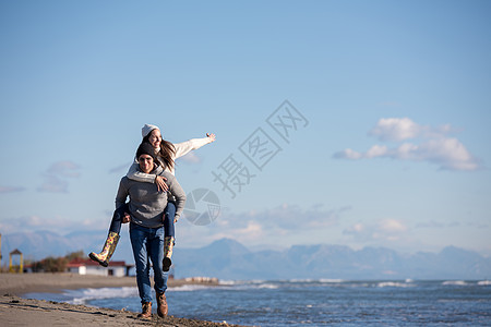 秋天在海滩玩情的情侣阳光乐趣异性女朋友夫妻幸福女性快乐海洋日落图片