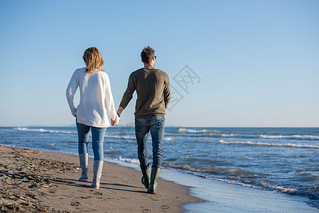 秋天阳光明媚的一天 在海滩上爱一对年轻夫妇互动冒充棉花夫妻自拍男人假期拥抱营火手机图片