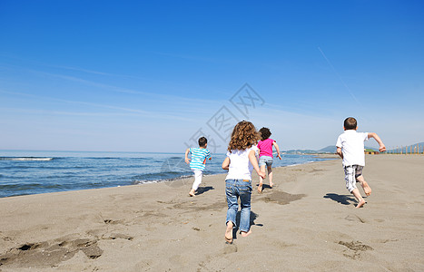 在海滩上玩耍的快乐儿童群体童年闲暇孩子男生团体头发跑步活力海洋海岸图片