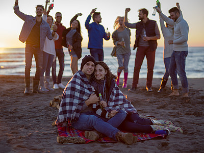在海滩日落时和朋友共度欢乐的情侣潮人幸福篝火活动假期休闲城市沙滩营火朋友们图片