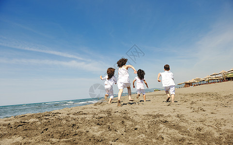 在海滩上玩耍的快乐儿童群体喜悦天空运动男生孩子朋友们生活活力团体海洋图片