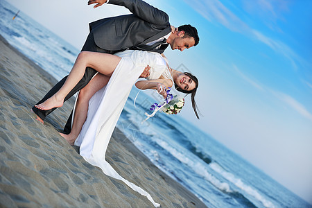 日落时的浪漫海滩婚礼成人面纱海洋花朵热带跑步婚姻海岸套装蜜月图片