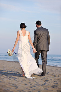 日落时的浪漫海滩婚礼热带海岸夫妻海洋女士喜悦成人女性跑步裙子图片