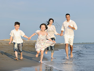 快乐的年轻家庭 在日落时在海滩上玩得开心假期童年孩子们女儿海洋微笑女孩乐趣男生旅行图片
