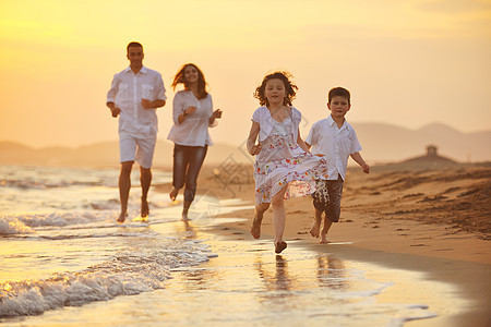 快乐的年轻家庭 在日落时在海滩上玩得开心天空女性海洋男生女儿孩子生活热带微笑妈妈图片