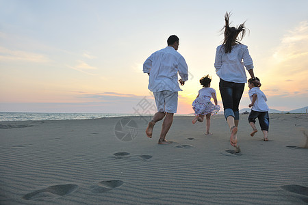 快乐的年轻家庭 在日落时在海滩上玩得开心旅行假期天空海洋母亲女儿成人孩子们女孩女性图片