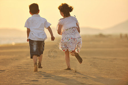 快乐的年轻家庭 在日落时在海滩上玩得开心天空父亲热带假期生活海洋母亲喜悦女性孩子图片