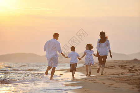 快乐的年轻家庭在海滩上玩得开心支撑跑步爸爸成人男人假期女性孩子女士父亲图片