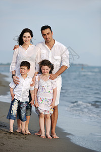 快乐的年轻家庭在海滩上玩得开心跑步活动闲暇喜悦女性父母孩子儿子海洋后代图片