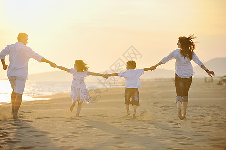 快乐的年轻家庭在海滩上玩得开心游客天空童年支撑假期后代微笑活动女士母亲图片