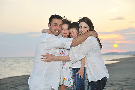 快乐的年轻家庭在海滩上玩得开心海洋游客乐趣父亲假期喜悦支撑闲暇男人母亲图片