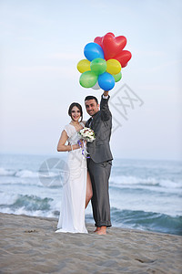 日落时的浪漫海滩婚礼夫妻海岸男性成人海洋女士跑步热带庆典婚姻图片