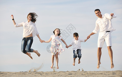 快乐的年轻家庭在海滩上玩得开心父母女儿童年喜悦儿子女孩假期孩子闲暇成人图片