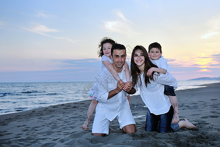 快乐的年轻家庭在海滩上玩得开心儿子后代旅行女性成人父母喜悦假期女孩乐趣图片
