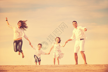 快乐的年轻家庭在海滩上玩得开心海洋女孩旅行父亲跑步爸爸后代女士男人父母图片