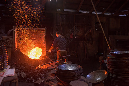 在车间使用机械锤子的铁匠工人制造业职业工具燃烧男人橙子团队工艺工匠火焰图片