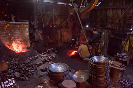 在车间使用机械锤子的铁匠工人金工团体燃烧工匠工具职业火焰辉光金属精神图片