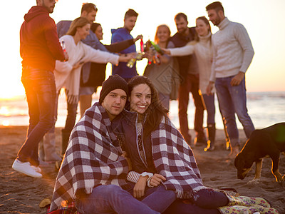在海滩日落时和朋友共度欢乐的情侣营火派对男人衣服旅行朋友们火焰幸福休闲篝火图片