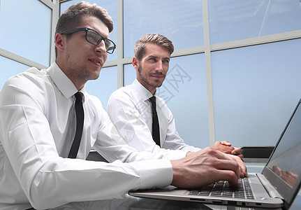 年轻办公室工人笑着微笑 同事在后脑室工作电脑商务伙伴人士会议团队男人项目笔记本对方图片