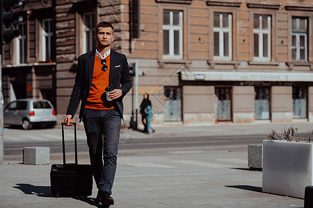 商务人士拿着手提箱走在街上旅行衣冠男人男性城市生活商务职业公文包成人皮革图片