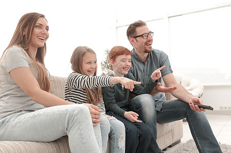 快乐的家庭在看他们最喜欢的电视节目男生公寓休息室渠道闲暇女士丈夫女儿手表兄弟图片