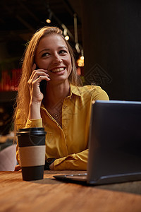 坐在咖啡店的年轻 身穿盛装的卡瓦西安青年妇女 由智能手机打电话女性互联网呼唤商业技术笔记本自由职业者咖啡咖啡馆晚餐图片