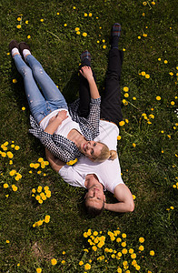 男人和女人都躺卧在草地上微笑男朋友女孩女士夫妻女性男性喜悦成人乐趣图片