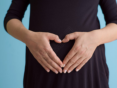 蓝色背景对孕妇的纵向照像母性婴儿腹部工作室怀孕生活幸福母亲女士父母图片