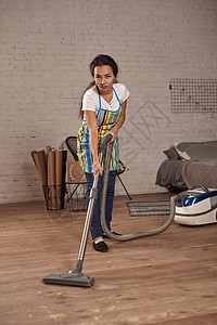 年轻妇女在家中客厅地板上使用吸尘器清洁工 做清洁工作和杂务 内地细心帮助技术垫圈工具家具地面电气电子产品女孩身份图片