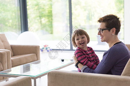 妈妈和可爱的小女孩 享受自己的空闲时间沙发孩子女孩女士乐趣童年家庭微笑女性母亲图片