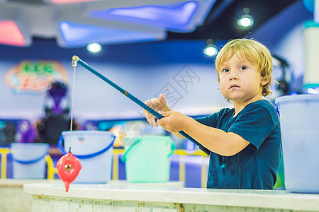 在游戏室钓鱼时可爱的男孩 发展精细运动概念 创造性游戏概念娱乐活动童年孩子乐趣朋友浮桥赤脚男性假期图片