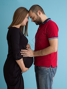 在蓝背景下被隔离的怀孕夫妇生活丈夫成人妈妈夫妻腹部母性家庭女性男性图片