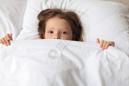 可爱的小女孩醒了 躺在床上婴儿毯子寝具女孩时间女性枕头童年卧室孩子图片