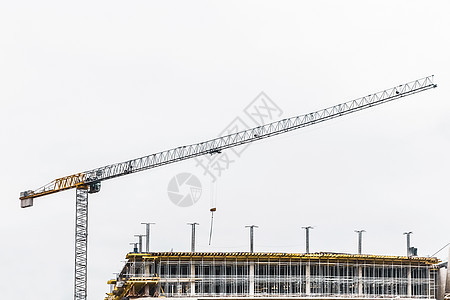 工业高塔起重机在建筑工地上建造新的混凝土城市大楼或公寓高楼蓝色水泥建筑学工程生长框架财产天空窗户图片