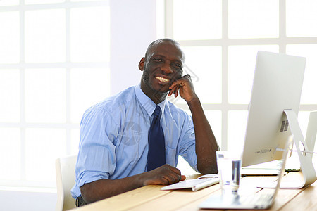 在笔记本电脑上工作的戴耳机的非裔美国商务人士文书衣服男人职业商务沉思铅笔人士经理审查图片