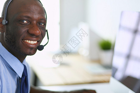 在笔记本电脑上工作的戴耳机的非裔美国商务人士审查沉思男性血统专注人士商务职业衣服办公室图片