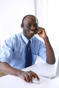 在笔记本电脑上工作的戴耳机的非裔美国商务人士商务沉思铅笔互联网文档检查男人专注办公室文书图片