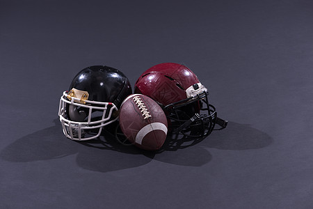 美国足球和头盔在灰色地带被孤立配件运动员竞技猪皮运动锦标赛娱乐橄榄球联盟体育场图片