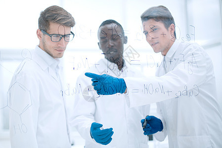 年轻的科学家在玻璃板上展示了一只手指团体蓝图测试玻璃合作器皿生物学男性化学家生物图片