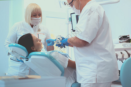 牙科办公室高级男牙医 与女病人交谈和准备治疗为治疗做准备医生考试药品口腔科卫生职业矫正男人牙齿女孩图片