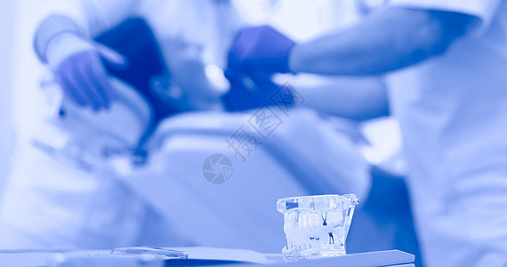 在诊所有女病人的牙医男子图片