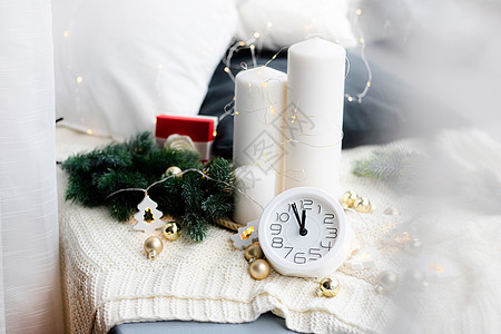 沙滩上的时钟加盖兰 白色手表 舒适的氛围 家庭舒适 新年和圣诞节季节警报花环软床蓝色格子时间毯子风格魔法背景图片