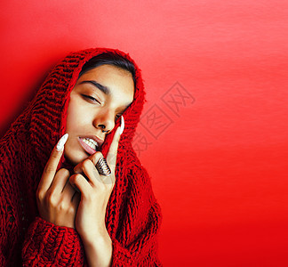 穿红色毛衣的年轻漂亮的印度女孩 装扮成情绪化 时时时流行的青少年 生活方式的概念头发女士女性衣服快乐微笑潮人发型季节图片