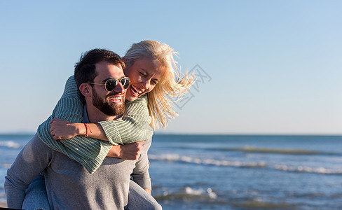 秋天在海滩玩情的情侣微笑骑术男人女朋友异性乐趣幸福假期女性夫妻图片