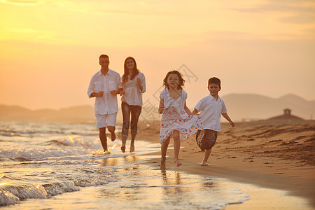 快乐的年轻家庭 在日落时在海滩上玩得开心旅行热带妈妈童年女性海洋跑步爸爸父母喜悦图片