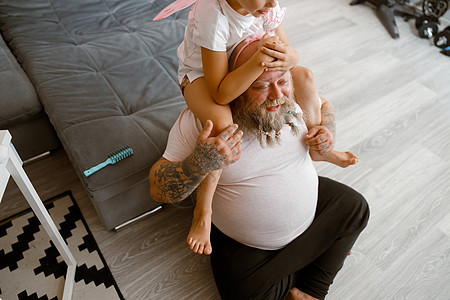 女儿坐在起居室中父亲的肩膀上 孩子长得非常丰满图片